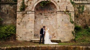 Sarah & James sharing a kiss at rustic traditional garden's of Drenagh Estate